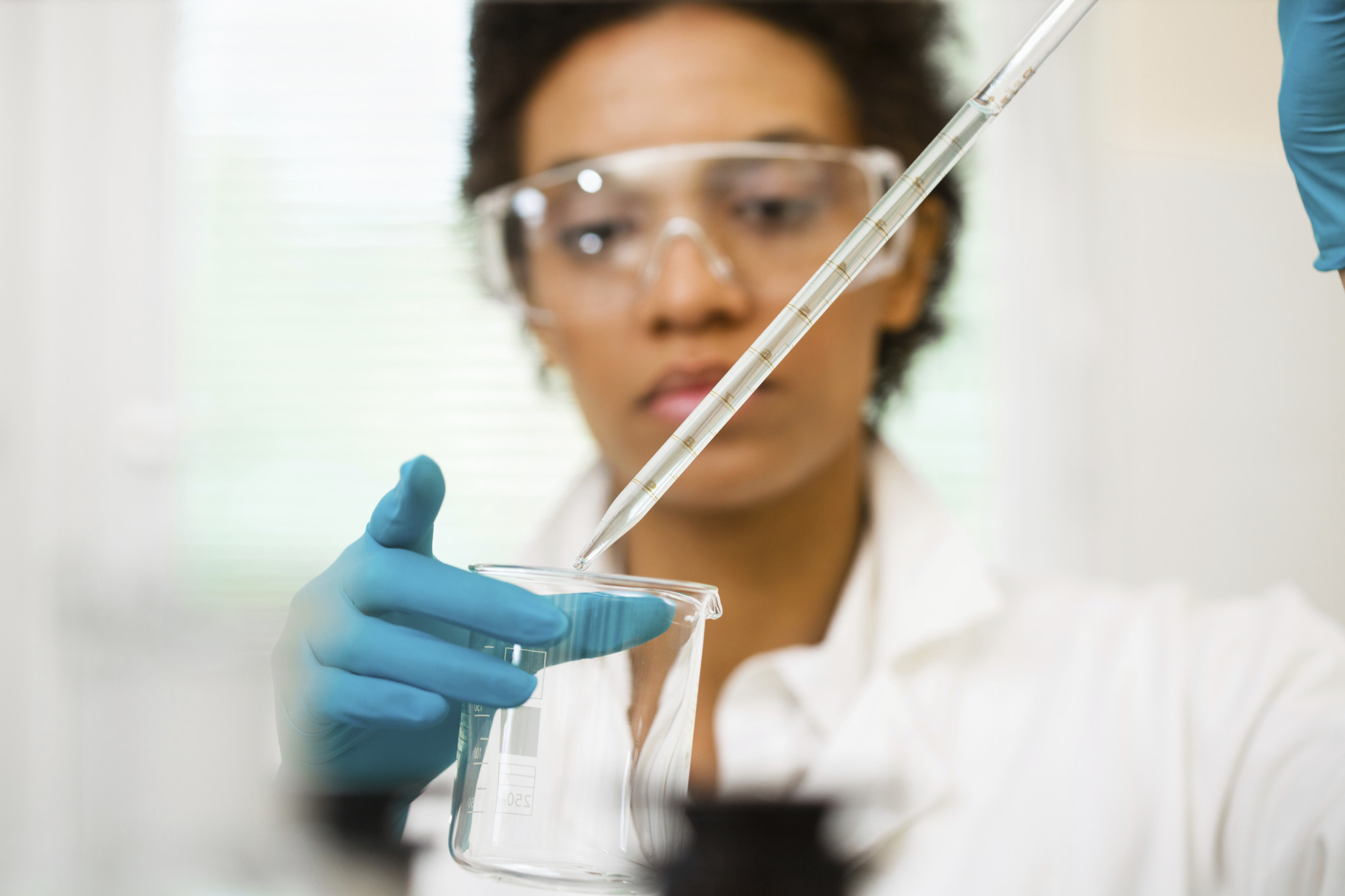 blurry woman scientist with beaker and test tube