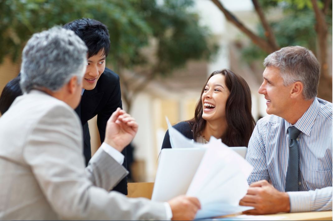 A presumed business meeting outside one woman three men all laughing color (2)